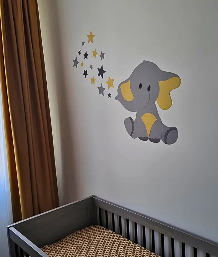 Okergele babykamer met een olifant behangsticker
